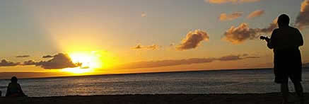 Ukelele player on beach at sunset