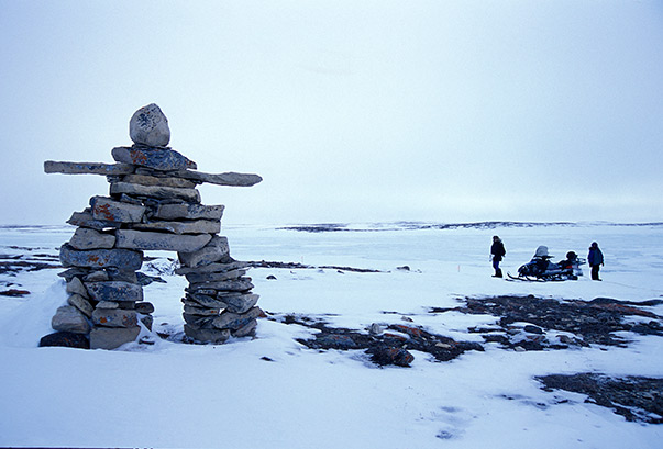 Snowmobiling in Nunavut near inukshuk