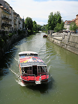 Boats cruise the Ljubljana River