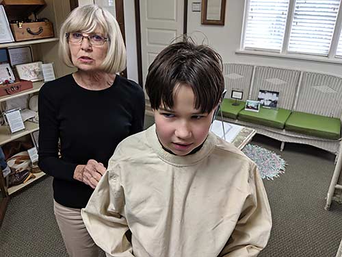 Erysee Elliott (left) tries on a straitjacket at the Utah State Hospital Museum in Provo.