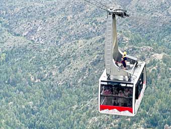 The cabin attendant rides the Sandia Peak tram car back down