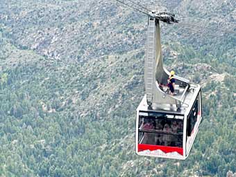 The “cabin attendant” rides the Sandia Peak tram car back down