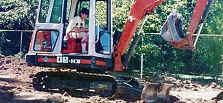 Author landscaping with backhoe