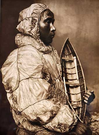 Nome - kayaker in studio portrait wears waterproof jacket and holds model kayak